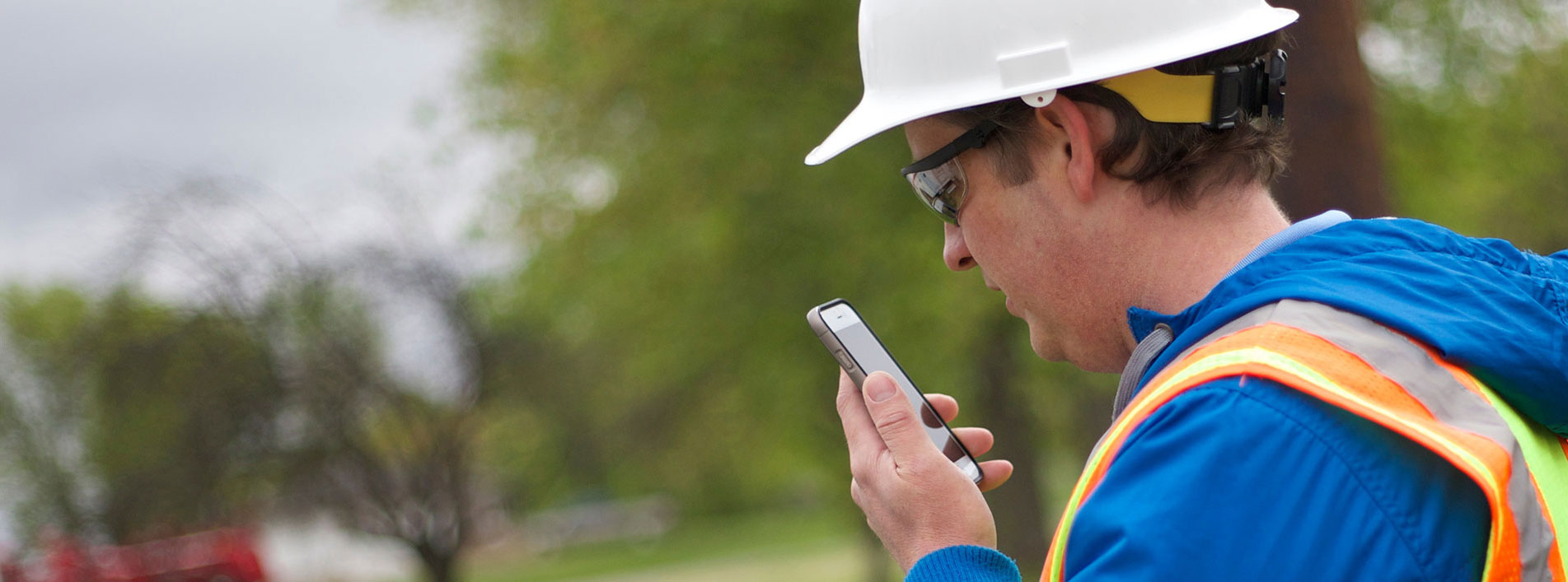 Man Wearing A Hard Hat Speaks Into A Mobile Phone