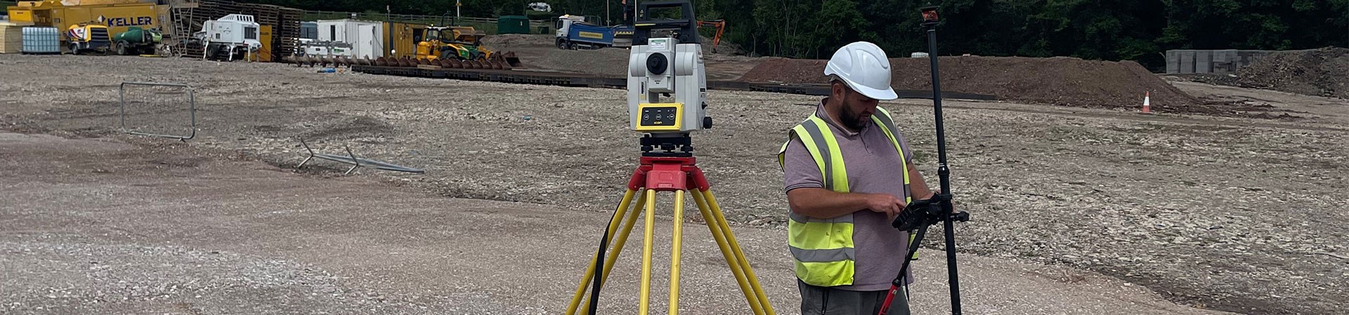 Robotic Total Station Onsite At Coed Drew Housing Development Being Used By A Surveyor Standing Next To It