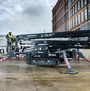 a black tracked access equipment on an open lot