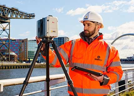 Engineer Setting Up A Survey Laser Scanner On Civil Engineering Project