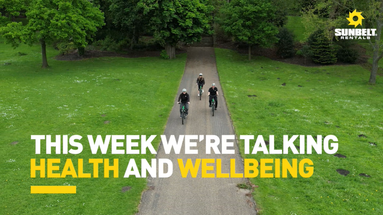 'This week we're talking health and wellbeing' text lay over image of three cyclists cycling on a park path surrounded by a field 