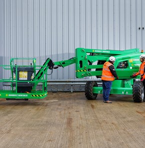 three operators inspecting a boom lift on a Sunbelt Rentals depot