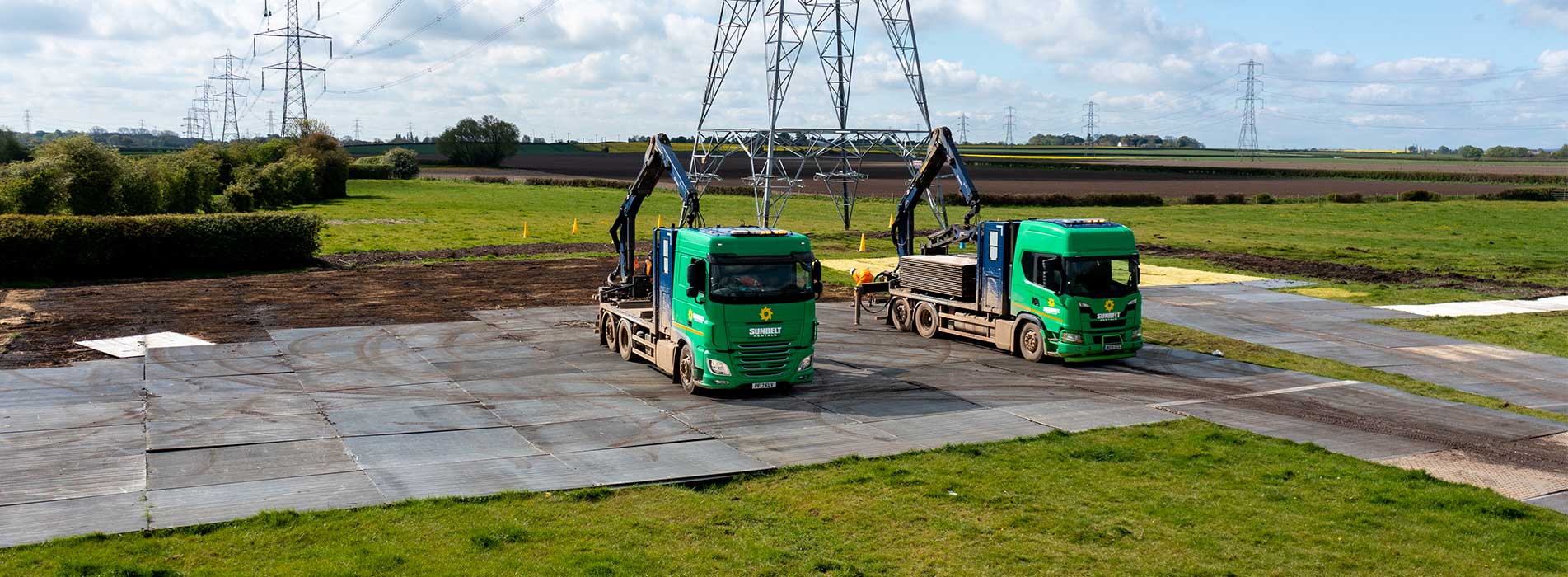 Two Trakway Trucks Laying Down Temporary Trakway On A Field