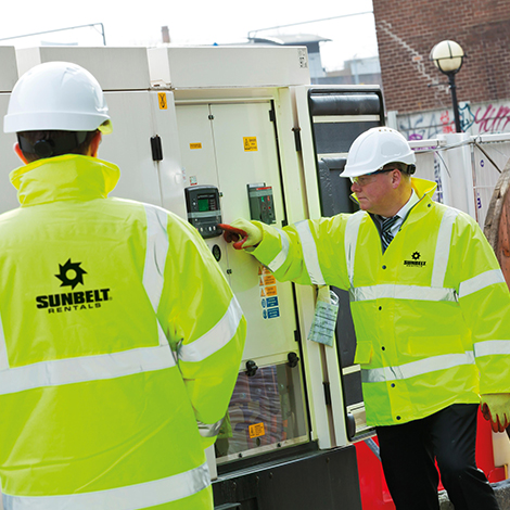 Two Sunbelt Rentals engineer inspect a generator that is on hire