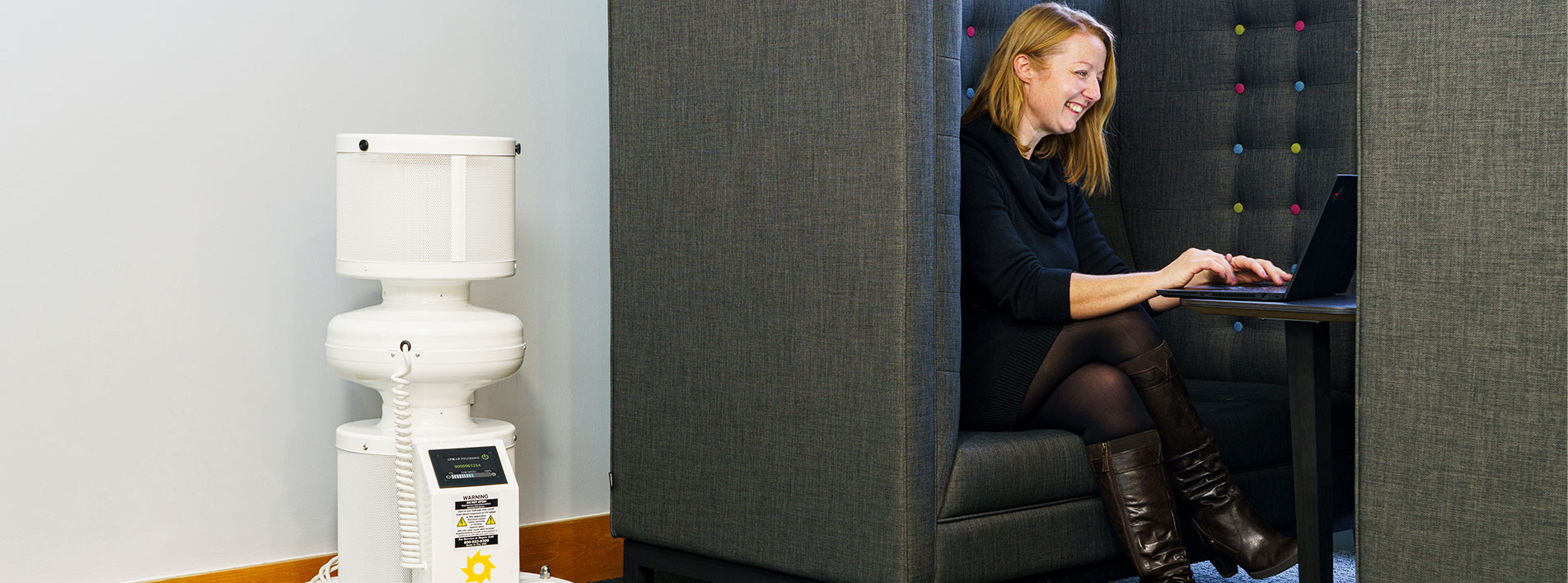 Lady On A Laptop At A Desk Next To S400 Air Disinfectant Device