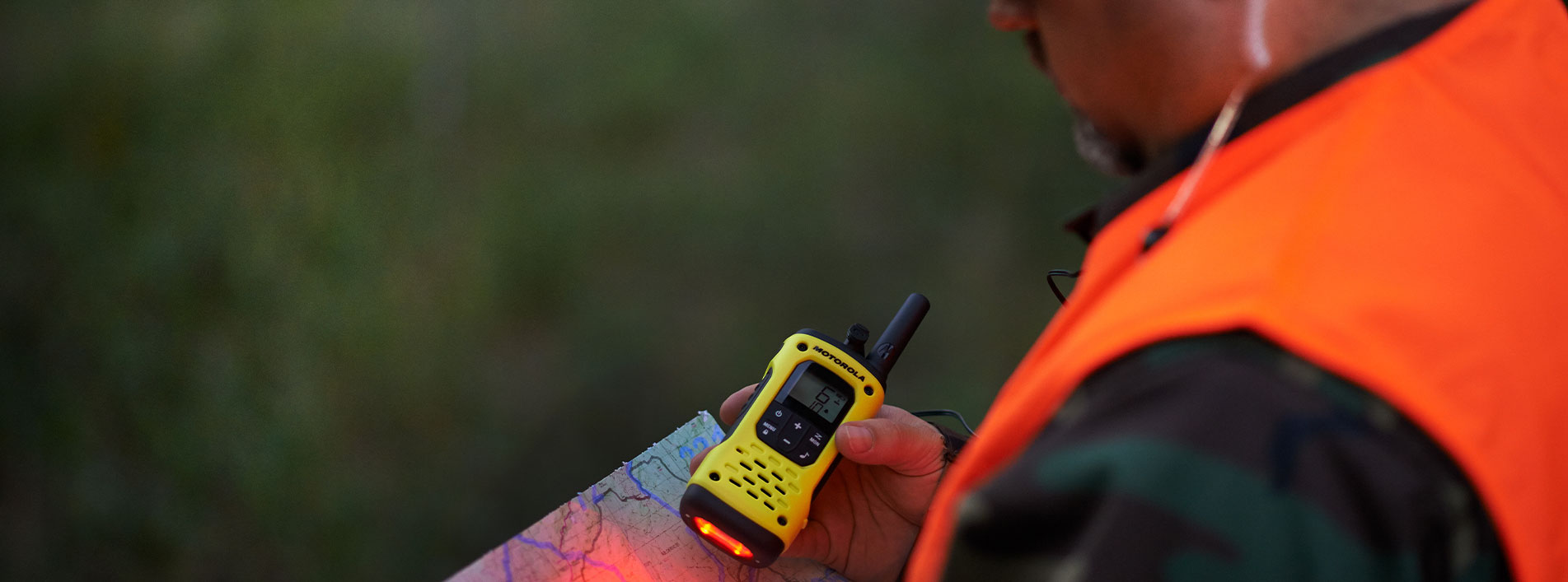 Man Holding A Two Way Radio In The Woods