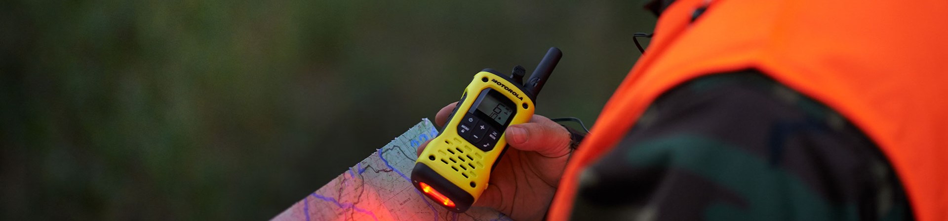 Man Holding A Two Way Radio In The Woods