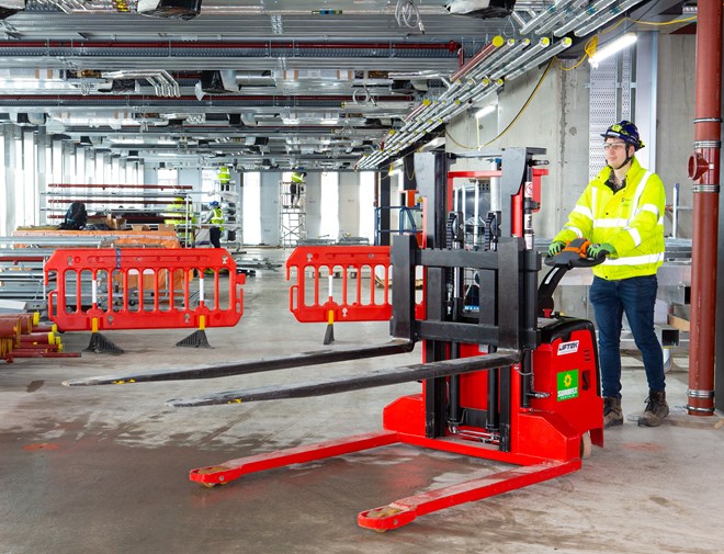 Custom Pallet Fork Truck Being Pushed In Warehouse By Worker