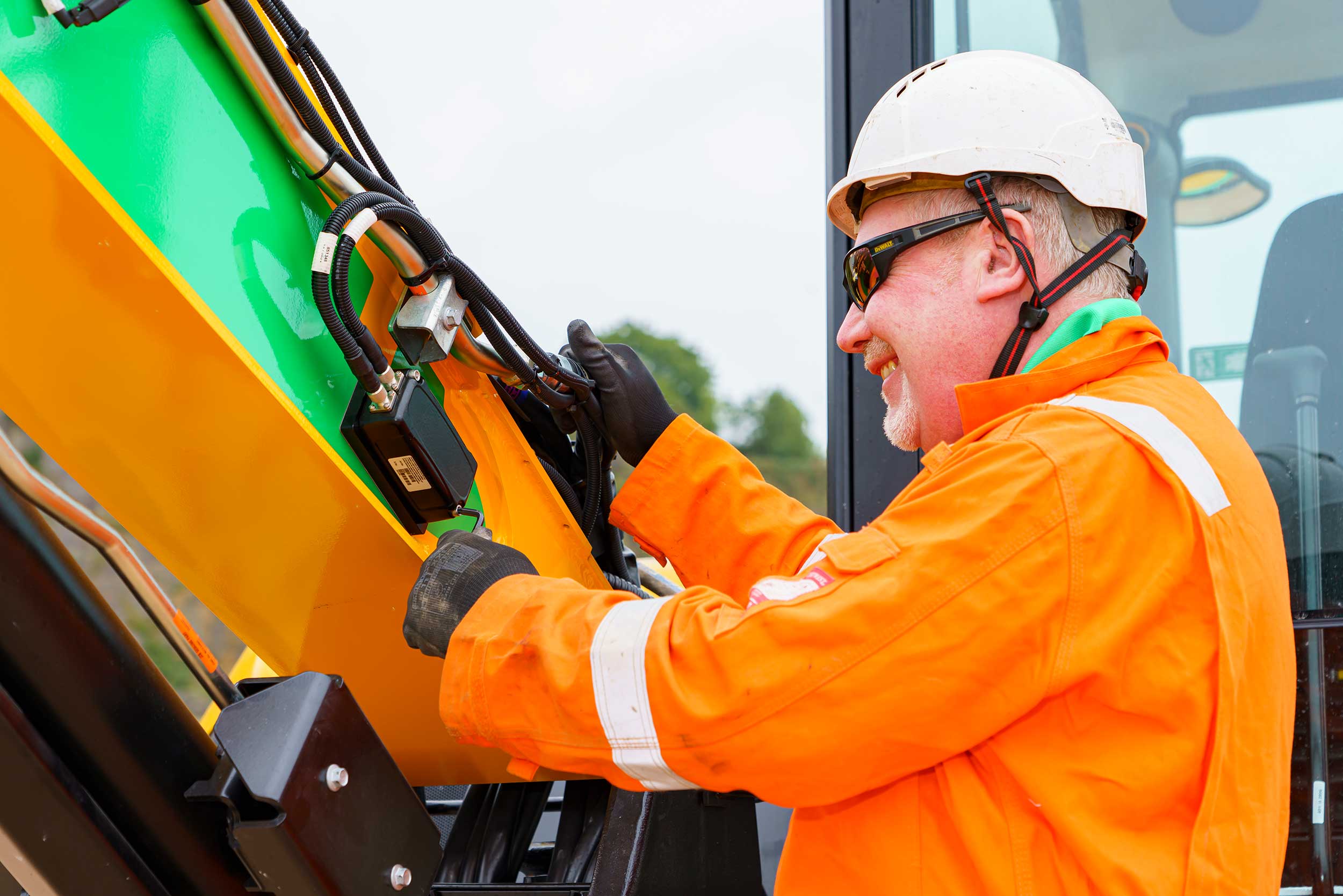 Engineer Servicing Machine Control On A Digger