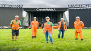 On Site Team Of Engineers Stood In front Of Creamfields Stage