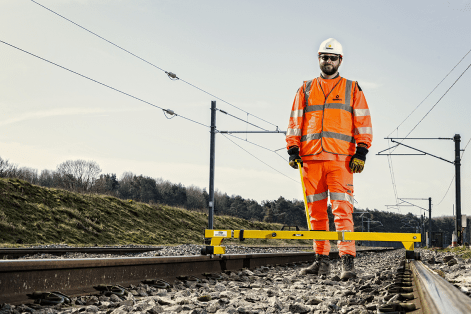 Sunbelt Rail Engineer Standing Over A Rail Gauge