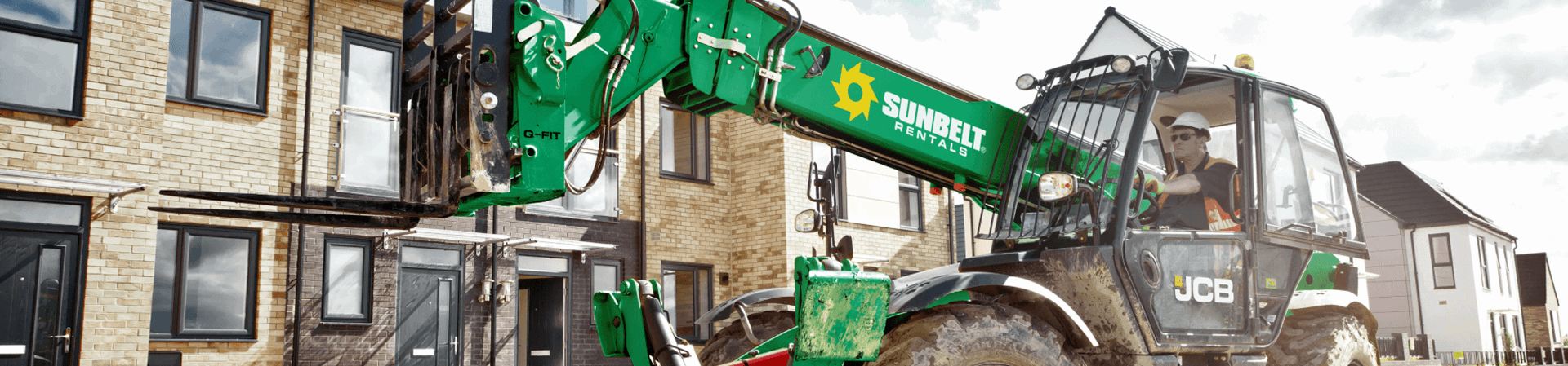Worker in Sunbelt Rentals plant machinery performing construction tasks